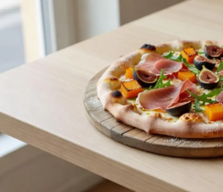 Autorska pizza z pieca opalanego drewnem serwowana w jasnej restauracji